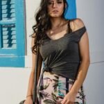 Woman in Grey Sleeveless Top Leaning on Wall